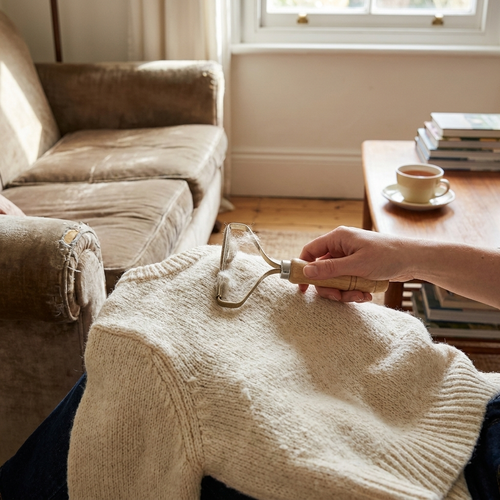 Wooden lint remover brush in use